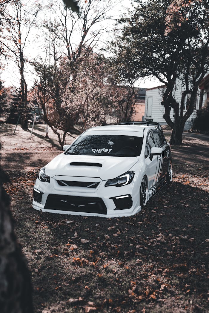 White Sports Car Parked Among Autumn Trees